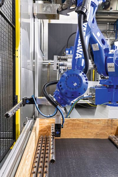 Mit Hilfe eines speziellen Greifers zum Eintauchen in radiale Bohrungen kann der Industrieroboter die gefertigten Rohrabschnitte eng gepackt in Transportkästen ablegen.   (Bild: Yaskawa Europe GmbH)