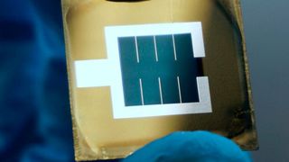 Die Perowskit/Silizium-Tandemsolarzelle des HZB. Zu sehen ist die aktive bläuliche Fläche in der Mitte des Wafers, die von der metallischen, silbrigen Elektrode eingeschlossen wird. (Bild: Johannes Beckedahl/Lea Zimmerman/HZB)