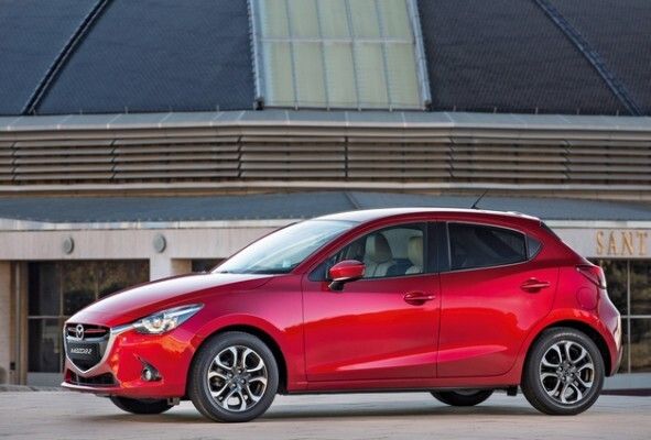 Red Dot Award 2015 - Mazda2: Der neue Mazda2 ist nach der herstellereigenen Designphilosophie „KODO – Soul of Motion“ gestaltet, wonach sich die natürliche Bewegung von Tieren im Design des Fahrzeugs widerspiegeln soll. Scheinwerfer, die an die Augen eines Raubtieres erinnern, verleihen der Front ein dynamisches Aussehen. Das markante Flügelmotiv des Kühlergrills setzt sich durch die Scheinwerfer in einer Konturlinie an der Fahrzeugseite fort. Durch Zuwachs an Länge und einen größeren Radstand hat der Mazda2 einen großzügigen Innenraum, der ergonomisch und komfortabel gestaltet ist. (Red Dot)