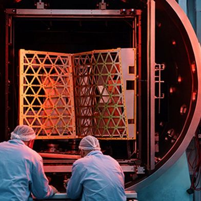 Two scientists in front of a vacuum chamber used for testing. (Source: Busch Group)
