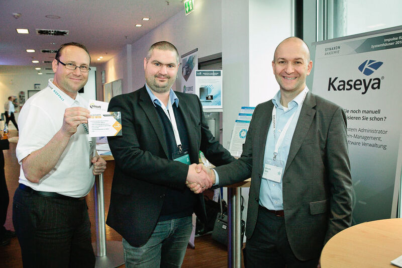 Lars Göntgens (Mitte, cosoft computer consulting) ist einer der Gewinner bei der
Kaseya-Verlosung Andreas Schmidt (r.) und Gerald Geis (beide Kaseya) gratulieren. (Astrid Piethan)
