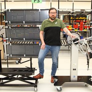 Stefan Strauss, Produktionsleiter bei Rose Bikes, mit dem selbst entwickelten Montagewagen (links), der noch bis 2020 im Einsatz war. Doch Fahrräder, deren Gewicht sich der 30 kg-Marke nähert, müssen in jeder Position leicht und rückenschonend erreichbar sein – das ermöglichte die lediglich höhenverstellbare Hilfe nicht. Rechts der neue Wagen „Bike Promobil“.(Bild:  Roemheld GmbH)