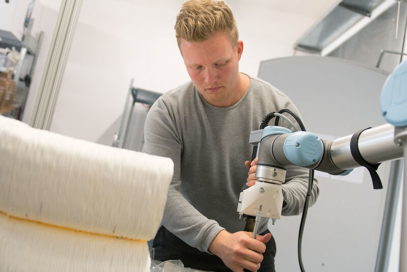 Moritz Wesseler stattet den Roboterarm mit einem Extruder aus. (FH Münster/Pressestelle)