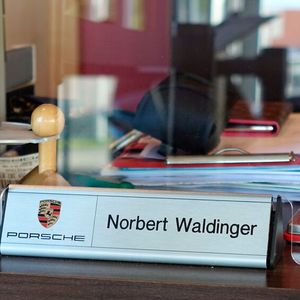 Aus seiner Zeit vor seinem eigenen Betrieb hat Inhaber und Kfz-Meister Norbert Waldinger lediglich den Porsche-Tischaufsteller mitgenommen, der heute noch zum Einsatz kommt.(Bild:  Schreiner/»kfz-betrieb«)