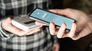 electronic-payment-via-smartphone-hands-holding-cellphone-making-a-money-transfer-contact-less-and-wireless-via-nfc-focus-on-fingers-stockpack-adobe-stock-scaled (Quelle: Lombardo-Adobe Stock)