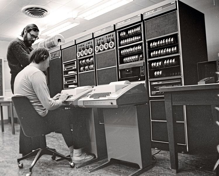 1970 – ein Betriebssystem in nur 8 KByte: Bis 1969 half der Bell-Labs-Angestellte Ken Thompson (sitzend) bei der Entwicklung eines Betriebssystems namens Multics, ein OS für die gleichzeitige Benutzung durch mehrere Nutzer, das eine nahtlose Verknüpfung von Festspeicher und RAM, prozessübergreifenden Datenzugriff und die Möglichkeit, das System im laufenden Zustand zu warten, bieten sollte. Als Bell Labs mit Verweis auf die hohen Kosten aus der Entwicklung ausstieg, setzte Thompson seine Arbeit möglichst günstig und auf eigene Initiative fort. Gemeinsam mit Dennis Ritchie (stehend) verfasste er eine Entwicklungsumgebung, die in den gerade einmal 8 KByte großen Arbeitsspeicher ihrer alten PDP-7-Entwicklungsmaschine passte. Um sich Arbeit bei der Portierung auf modernere Geräte zu sparen schrieben die beiden spätere Versionen nicht in Assembler, sondern in einer Programmiersprache, so dass Unix schnell auf verschiedensten Rechnern zum Einsatz kam. Das OS führte unter anderem zu der Entstehung von C, Linux und – indirekt – dem Open-Source-Gedanken.  (Bild: Peter Hamer / CC BY-SA 2.0)