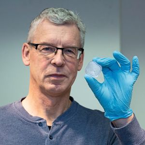 Untersuchungen geringster Materialmengen: Kosmochemiker Prof. Frank Brenker zeigt drei Körnchen eines Meteoriten, mit dem das Team der Goethe-Universität Untersuchungsmethoden vorab testete. Die Menge und Art entsprach dem Material des Asteroiden Bennu.(Bild:  Uwe Dettmar für Goethe-Universität)
