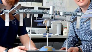 Claas Olthoff (li.) und Daniel Pütz mit einem Modell der Internationalen Raumstation. (Bild: Stefanie Reiffert / TUM)