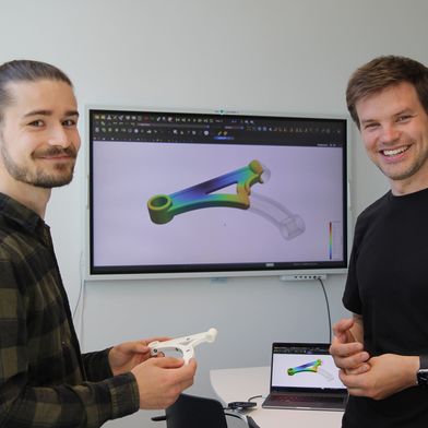 Nils Meyer (rechts) und Projekt-Mitarbeiter Julian Greif entwickeln ein KI-Tool, um die Bauteilentwicklung im Spritzguss zu optimieren.  (Bild: Universität Augsburg)
