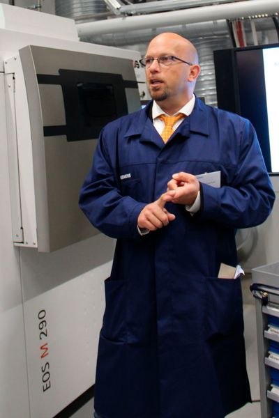 Der Chef des 3D-Druck-Teams in Finspang, Andreas Graichen, sieht nicht nur in der Additiven Fertigung Vorteile, auch die Digitalisierung soll in der Halle Einzug halten. Er sieht Roboter, die um die Drucker herum logistische Aufgaben und die Säuberung übernehmen, während Menschen sie beaufsichtigen. (Käfer)