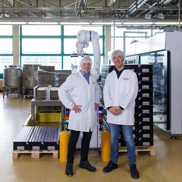 Ein starkes Trio: Hannes Langreiter von Profipack (links), Anton Weber von der Privatmolkerei Bauer und der Yaskawa Cobot. (Bild: Yaskawa Europe)