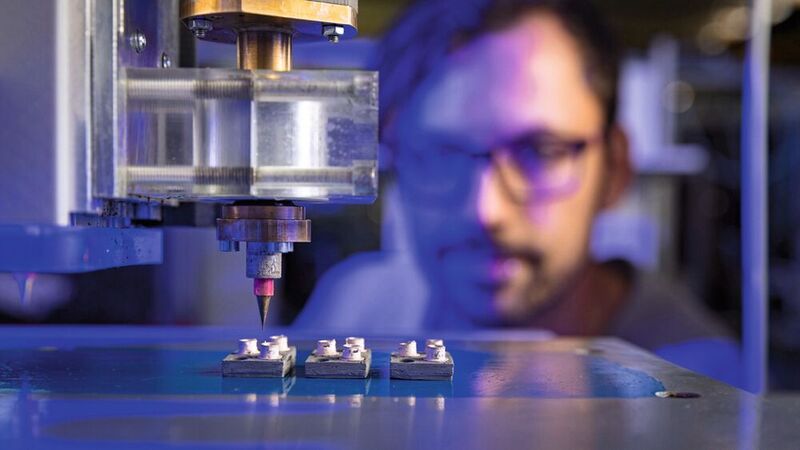 Bild 1: Johannes Rudolph, TU Chemnitz, beobachtet den 3D-Druck von Gehäusen für leistungselektronische Bauelemente. (Bild: TU Chemnitz / Jacob Müller)