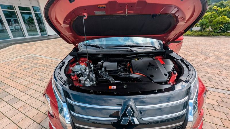 3. Das Antriebskonzept: Unter der Motorhaube des Mitsubishi Outlander ist ein 100 kW/136 PS starker 2,4-Liter-Benziner verbaut. In Kombination mit zwei E-Motoren an der Vorder- und Hinterachse, die für den Allradantrieb sorgen, liegt die Systemleistung bei 225 kW/306 PS. Für den Sprint von Null auf 100 km/h benötigt das Modell knapp acht Sekunden. Der Antrieb erwies sich auf den Testfahrten als harmonisch, kraftvoll und angenehm leise.  (Bild: Mauritz – VCG)