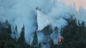 A Sikorsky S-70i Firehawk helicopter operated by CAL FIRE releases water over a burning hillside. (Source: CAL FIRE / CC BY-NC 4.0)