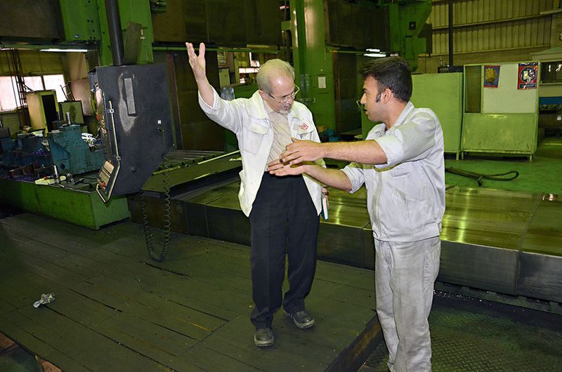 Betriebsleiter Sadri (links) diskutiert ein Fertigungsproblem direkt an der 5-Achs-Maschine.   (Jablonski)