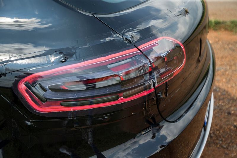 ... denn bei der Testfahrt verbarg sich die neue Optik noch unter dicker schwarzer Folie mit Fake-Rückleuchten, -Scheinwerfern und -Schwellern. (Bild: Porsche)