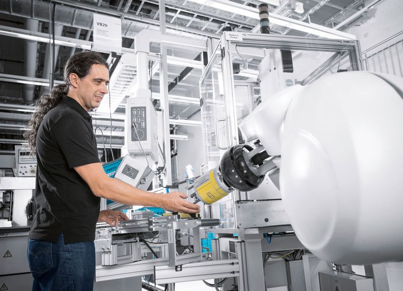 Blick in die Technologiefabrik von Festo in Scharnhausen: Der Montageroboter arbeitet in der Ventilmontage direkt und ohne Schutzkäfig mit dem Menschen zusammen. (Bild: Festo)