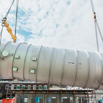Ein Schwergewicht: Zwei Kräne heben den fast 100 Tonnen wiegenden Fallfilmverdampfer in die Luft. (Bild: BASF)