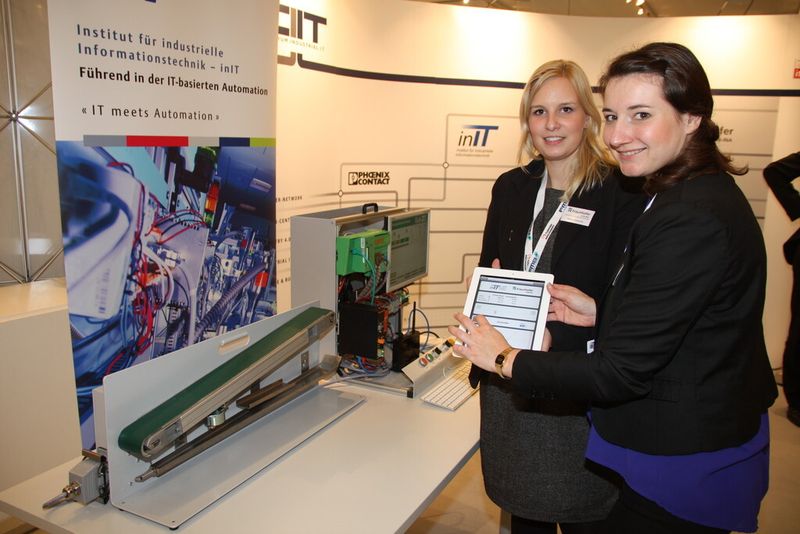 Carolin Schönknecht, Fraunhofer IOSB-INA, und Franziska Hildebrand, CIIT, zeigen am Beispiel eines Energiedemonstrators, wie Anlagen selbständig lernen können, am energieeffizientesten zu produzieren.  (Finus)