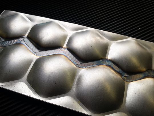 So sehen Bleche aus, die per gewölbter Struktur mit wabenförmiger Grundfläche versteift sind. Solche Komponenten sind gut für den Leichtbau, aber nicht einfach zu verschweißen. Mit einer neuartigen Rollennahtelektrode klappt das aber jetzt ohne die üblichen Probleme, sagt Time.(Bild:  Time)