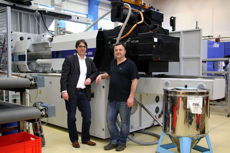 V.l.: Marcus Otto, Vertriebsmann bei Wittmann Battenfeld und Horst Wodak, der Geschäftsführer und Eigentümer von UPT-Optik Wodak, vor der Macropower.  (Wittmann Battenfeld)