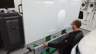 Die Ausrichtung des Kalibriergestells gelingt beim CSC Tool Digital von Hella Gutmann dank Abstandslaser mit Bluetooth-Verbindung deutlich schneller. Eine App projiziert die Werte auf den großen Beamer-Bildschirm. (Bild: Dominsky/»kfz-betrieb«)