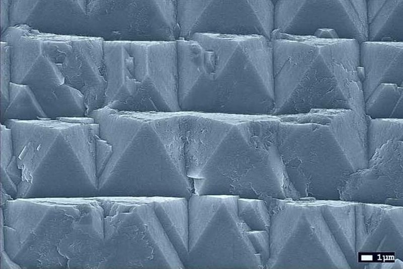 Diamanten für Quantentechnologien    NV-dotierter Diamant* gehört zu den aussichtsreichsten Materialien für die Realisierung von Quantentechnologien. Bislang ist er aber kaum in industriegeeigneter Qualität und Quantität verfügbar. Das Fraunhofer-Institut für Angewandte Festkörperphysik (IAF) entwickelt daher gemeinsam mit deutschen Industrieunternehmen im Projekt „GrodiaQ“ Prozesse und Anlagen, um die industrielle Nutzung von (111)-orientierten Diamant-Substraten zu ermöglichen. Die Substrate werden u. a. mittels Elektronenmikroskopie-Aufnahmen analysiert (im Bild: frühe Wachstumsphase von Diamant auf einem Wafer). *NV steht für „nitrogen vacancy“, also Stickstoff-Leerstelle; Ein NV-dotierter Diamant enthält geringste Mengen an Stickstoffatomen, wodurch im Kohlenstoffgitter des Diamanten Leerstellen entstehen, die dem Material besondere (optische) Eigenschaften verleihen.   Hier gehts zur Originalmeldung Wissenschaftsbild des Tages vom 26.7.2022  (Fraunhofer IAF)