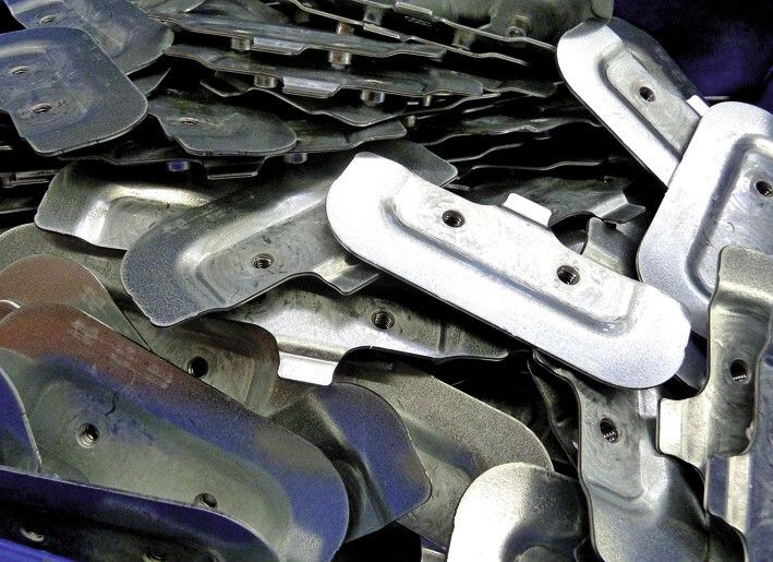 Beispiel von gestanzten und umgeformten Gutteilen, die in transportable Behälter fallen und somit zur Weiterverarbeitung oder zur Lieferung bereitstehen. (Bild: Kuhn)
