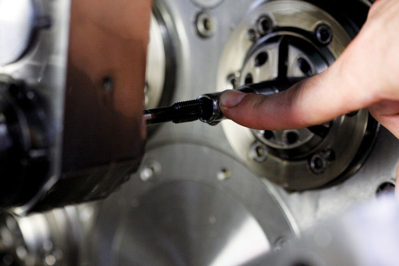 Blick auf den Fertigungsprozess ab Stange und auf die aufgeschnittene Gewindebuchse. Der Gewindeschneider muss zirka 20 mm in das Werkstück eintauchen, bevor es ans Zerspanen geht. Dank Sackloch (ab Stange) und 20-bar-Hochdruckkühlung werden die Späne sicher aus der Prozesszone nach hinten abgeführt. (Bild: Matthias Böhm)