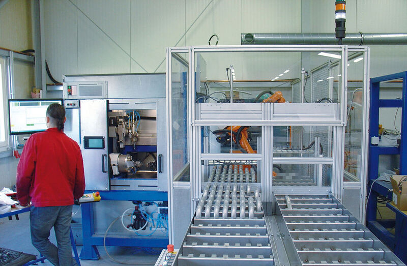 Die automatisierte doppelstrangige Teilezuführung der Laserschneidanlage (links): der Knickarmroboter (im Hintergrund) belädt die Maschinen immer mit dem passenden Werkstück. (Bild: Famag Robotik & Automation GmbH)