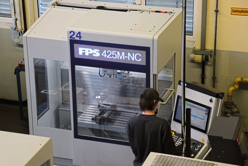 Nach finaler Freigabe durch den Ausbildungsmeister beginnt der Zerspanungsprozess, der gut durch die großen Scheiben der komplett geschlossenen Umhausung betrachtet werden kann. (Bild: FPS Werkzeugmaschinen)