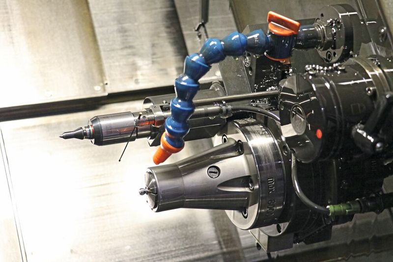 Durch die oberhalb vom Spindelstock angebrachte Reitstockspitze können lange, dünne Werkstücke abgestützt werden. Parallel dazu kann an der Gegenspindel gearbeitet werden.(Bild:  Teamtec)