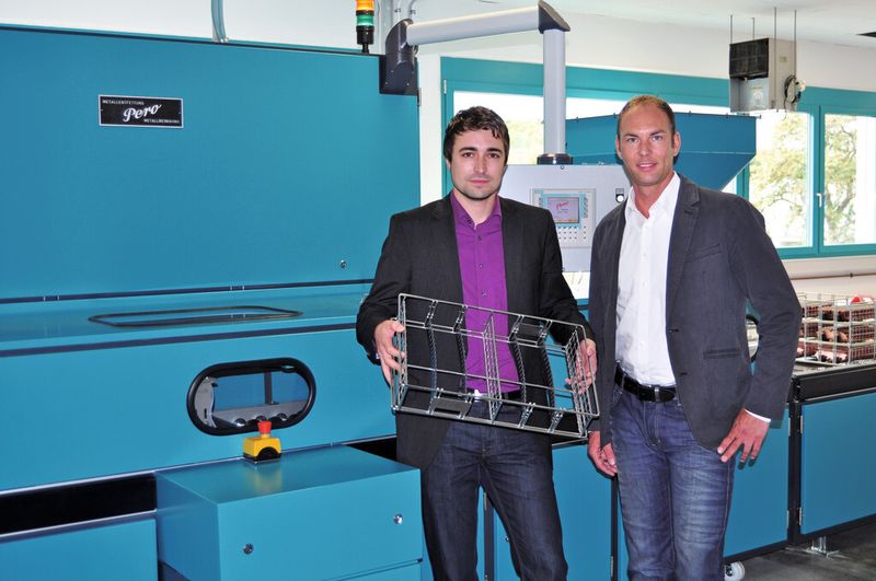 Dipl.-Ing. (FH) Steffen Walter (links), Geschäftsfeldleiter Entwicklung & Baugruppen bei Kleiner Stanztechnik, zeigt Thomas Schwarz (rechts), Fachberater bei Pero, den Warenträger, in dem alle fünf verschiedene Blechteile zur Herstellung eines elektrischen Leistungsmoduls gereinigt werden. (Bild: Schmidt)