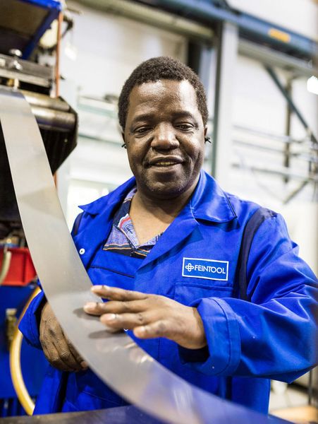 Ein Feintoolmitarbeiter beim Einspannen eines Stahlcoils. (Bertram Bölkow / Feintool)