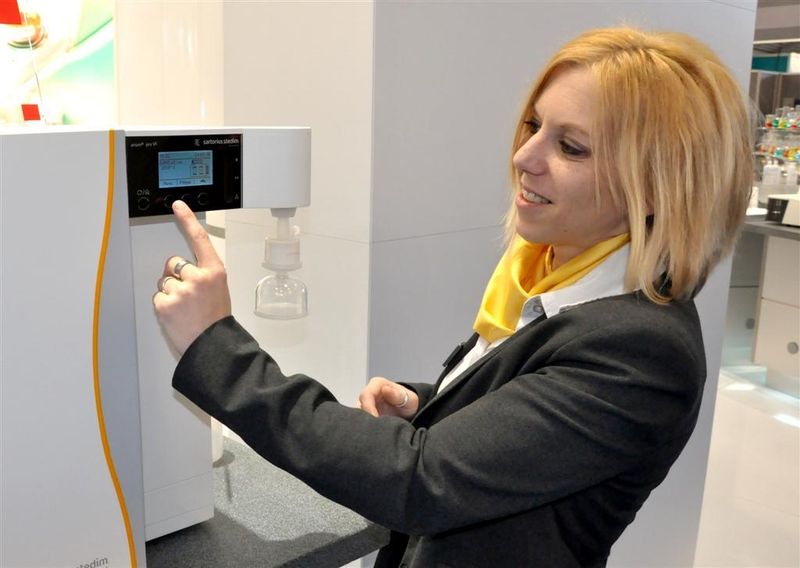 Sartorius Stedim Biotech präsentiert auf der Analytica 2010 erstmals das ASTM Typ 1 Reinstwassersystem Arium. Sophie Charlotte Rodefeld demonstriert am Messestand, wie sich alle Arbeitsabläufe bei der Reinstwassererzeugung Über das integrierte Glasdisplay mit Touch-Funktion effizient steuern und ausführen lassen. Die Entnahme ist volumengesteuert und zeitgesteuert möglich, die Flussleistung kann stufenlos justiert werden. Eine hohe Kapazität der Aufreinigungskomponenten ermöglicht lange Wartungsintervalle und niedrige Betriebskosten. (Archiv: Vogel Business Media)