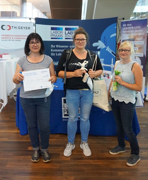 Blick nach vorn und Lächeln: Für ein Foto nahmen die Gewinnerinnen des Gewinnspiels kurz ihre Masken ab. Die Preise: Ein 1000-€-Einkaufsgutschein und zwei Plüsch-Mikroben.  Alle Infos zu den LAB-SUPPLY-Messen – Termine, Vortragsprogramm und Ausstellerliste – finden Sie unter www.lab-supply.info (LABORPRAXIS, Krause)