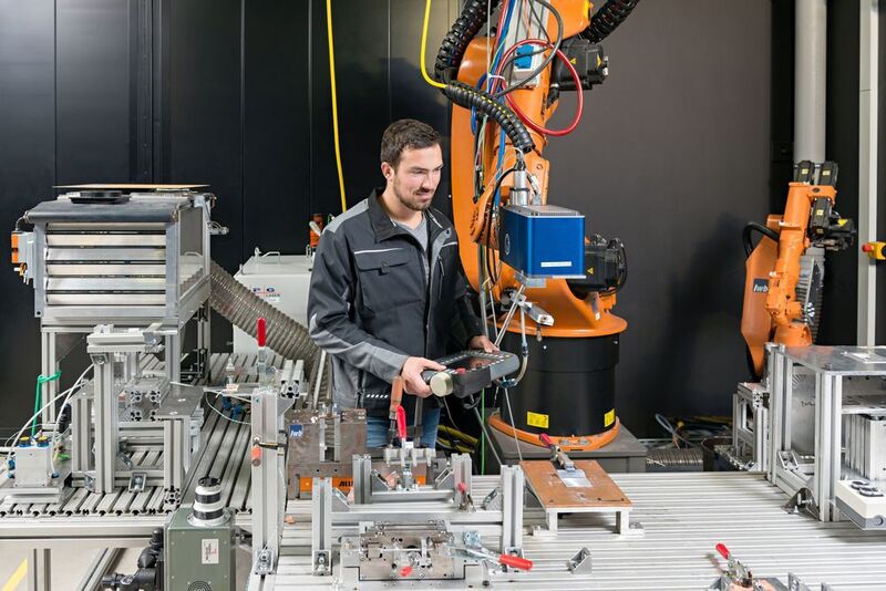 André Heckert, wissenschaftlicher Mitarbeiter am iwb, positioniert den Laser für die Bearbeitung des Metalls für das Fügen von Metall- Kunststoff-Verbindungen. (Bild: Uli Benz/TU München)