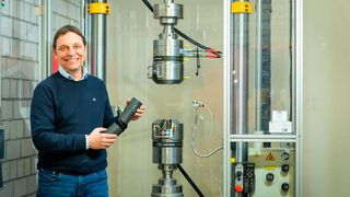 Projektleiter Prof. Dr. Jochen Blaurock vom Institut für Fahrzeugtechnik der TH Köln vor dem Hydropulser, mit dem die Experimente im Forschungsprojekt durchgeführt wurden. (TH Köln)