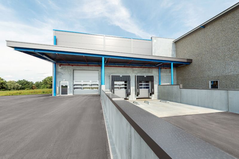 Mit der neuen Laderampe bei der Erwin Halder KG können die Lkw nun schneller be- und entladen werden. Nicht zuletzt bleiben die Protagonisten dabei nun auch bei Regenwetter trocken. (Bild: Halder)