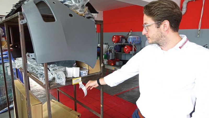 Maximilian Stein erläutert beim Rundgang das System der gekennzeichneten Ersatzteilwagen für jeden Auftrag. (Bild: Dominsky/»kfz-betrieb«)