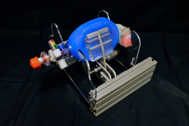 The new device fits around an Ambu bag (blue), which hospitals already have on hand in abundance. Designed to be squeezed by hand, instead they are squeezed by mechanical paddles (center) driven by a small motor. This directs air through a tube which is placed in the patient's airway. (Courtesy of the researchers)