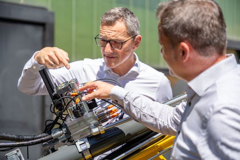 Bernd Winkler und RWT-Vorstand Reinhard Thor besprechen das Wechselspiel der vier Schieber-Sitzventile am CPS-Block beim Eilgang und Regenerationsgang. (Bild: Pecksteiner/LCM)