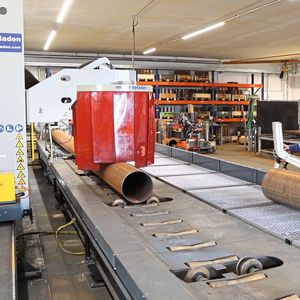 Über einen 16 Meter langen Rollgang-Förderer werden die außerhalb der Halle gelagerten Rohre bis 8.000 Kilo Stückgewicht der Schneidanlage zugeführt. Der vollautomatisierte Schneidtisch der Anlage besitzt 12 höhenverstellbare Rohrunterstützungen, die sich automatisch der zum Teil unrunden Rohroberfläche anpassen und so für eine perfekte Auflage über die gesamte Rohrlänge sorgen.(Bild:  Müller Opladen)