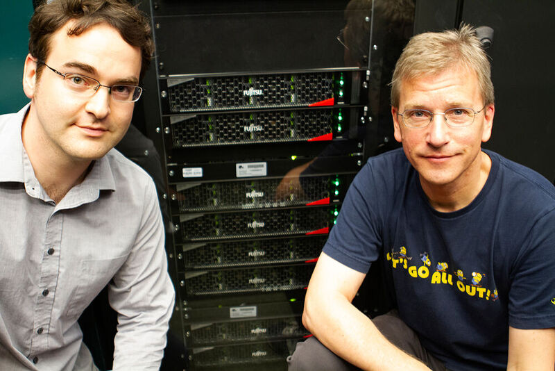 Professor Dr. Christoph Lehner (links) und Professor Dr. Tilo Wettig (rechts) vor dem neuem Supercomputer der Universität Regensburg.