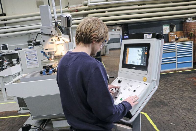Nachdem Azubi Jeremy Kemp mit dem Handrad an der Fräsmaschine FPS 500M-digital Gefühl fürs Metall bewiesen hat, darf er im nächsten Schritt an die integrierte Streckensteuerung Heidenhain PT 8016FPS. Die Touchpad-Bedienung erleichtert insbesondere den jungen Auszubildenden den Umgang mit der Steuerung.  (Bild: FPS Werkzeugmaschinen)