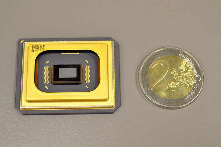 Herzstück des Laser-Scheinwerfers ist das sogenannte „Digital Micromirror Device“ (DMD) von Texas Instruments. Die auf dem DMD-Chip glänzende kleine Spiegelfläche, von einer Kaffeebohne fast abzudecken, ist keine Einzelfläche, sondern besteht aus 420.000 einzeln verstellbaren Mikrospiegeln. (Foto: Audi)