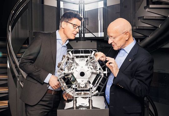 Alexandre Pauchard und Claude Nicollier betrachten ein in 3D gedrucktes System für das von der Europäischen Kommission im Rahmen von Horizont 2020 finanzier­te Projekt  PULSAR. «Wir verwandeln Technologie in Hoffnung.»(Bild:  Guillaume Perret)