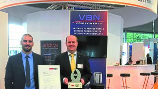 CEO Martin Nilsson (r) and Process Engineer, Kristoffer Cederferm, at the company booth at EMO, proudly presenting the innovation award VBN won in additive manufacturing. (VBN Components)