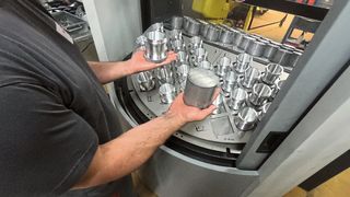 Während der Roboter an der Vorderseite eine Maschine mit neuen Werkstücken belädt und Fertigteile entnimmt, kann ein Bediener auf der Rückseite hauptzeitparallel die produzierten Teile aus dem Puffer nehmen und die Zelle mit Rohteilen bestücken. (Bild: Halter CNC Automation)