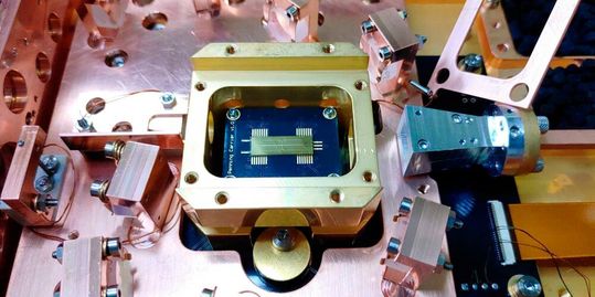 Apparatur für die Experimente: In der goldfarbenen Halterung liegt der Fallenchip, auf dem ein einzelnes gefangenes Ion die Störfelder messen und davon eine dreidimensionale Karte erstellen kann. (Bild:  Edgar Brucke / ETH Zürich)